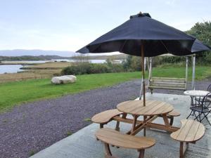 a picnic table and bench with an umbrella at River House in Hollywood