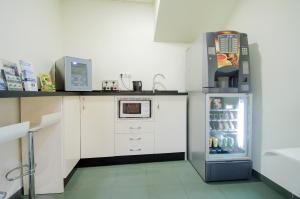una pequeña cocina con nevera y microondas en Hotel Solymar en Málaga