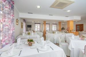 a banquet hall with white tables and white chairs at Hotel La Terraza De Puente Viesgo in Puente Viesgo