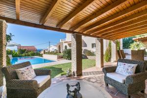 蘇尼翁的住宿－Villa Melia，一个带桌椅的庭院和一个游泳池