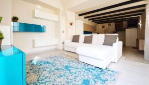ein Wohnzimmer mit einem weißen Sofa und einem blauen Teppich in der Unterkunft Casa Pont1 in Scala