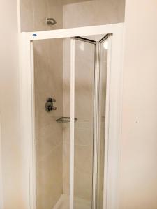 a shower with a glass door in a bathroom at Kings Court Holiday Apartments in Tralee