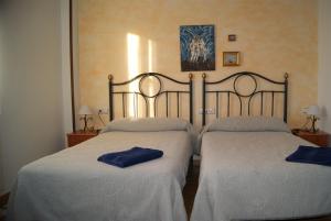 two beds in a room with blue towels on them at Hotel Rural Casa El Cura in Calzadilla de los Hermanillos
