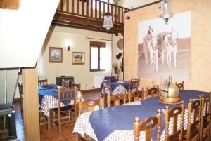 a dining room with tables and chairs and a painting on the wall at Hotel Rural Casa El Cura in Calzadilla de los Hermanillos