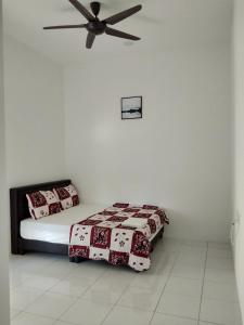 een slaapkamer met een bed en een plafondventilator bij Sleepee Homestay in Teluk Intan