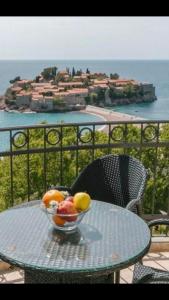 a bowl of fruit on a table on a balcony at Monte Perla Residence in Sveti Stefan