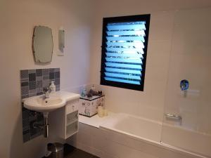 een badkamer met een wastafel, een bad en een raam bij Sinclair Eco House in Port Lincoln