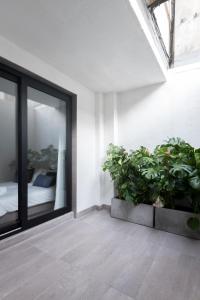 una stanza con piante e una finestra con un letto di Lisbon Domus 74 by amcf a Lisbona