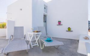 un patio con 2 sillas y una mesa con un tazón. en Traditional House by the Sea en Mandrakia