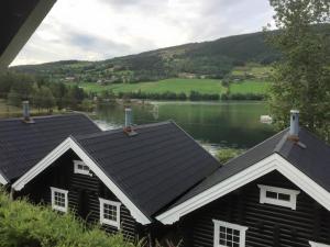 um chalé de madeira com vista para um lago em Fosheim Hytter em Ron