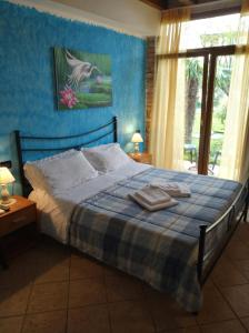 1 dormitorio con 1 cama con pared azul en B&B Il Rondò Sirmione, en Sirmione