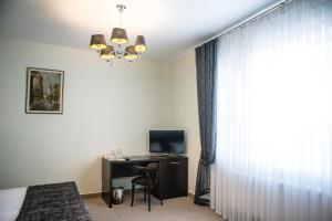 a bedroom with a desk and a bed and a window at Churchill-Inn in Vinnytsya