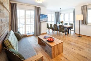 a living room with a couch and a table at Hotel Almschlössl & Schrotteralm in Obertauern