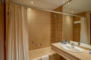 a bathroom with a sink and a tub and a shower at Safir Hotel Cairo in Cairo