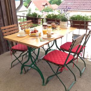 - une table en bois avec 2 chaises et des boissons sur la terrasse dans l'établissement Ferienwohnung am Reinhardswald -Buchenzweig-, à Trendelburg