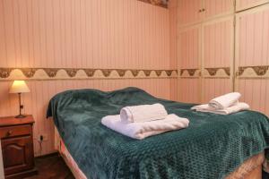 Un dormitorio con una cama verde con toallas. en Rosario microcentro 3 dormitorios. Downtown 3 bedroom en Rosario