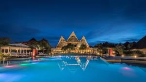 uma vista nocturna para uma piscina num resort em Essque Zalu Zanzibar -Life's Perfect sometimes em Nungwi