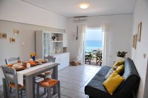 a living room with a table and a couch and a dining room at Myrto Homes Lefkada Agios Nikitas Greece in Agios Nikitas