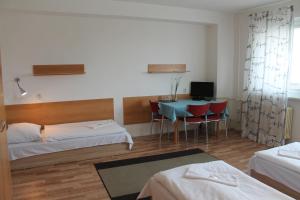 a hotel room with two beds and a table with chairs at Hostel Turist in Zvolen