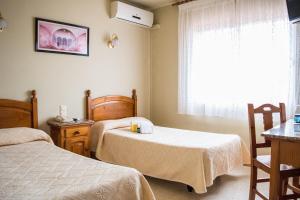 una camera d'albergo con due letti e una finestra di Hostal Las Torres a Martorell