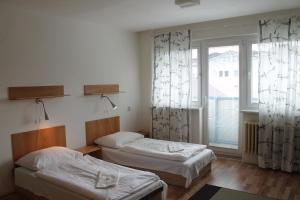 two beds in a room with a window at Hostel Turist in Zvolen