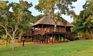 a large wooden house with a thatched roof at Elephant Walk Retreat in Komatipoort