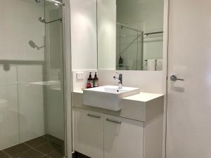 a white bathroom with a sink and a shower at Apres in Dinner Plain