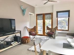 a living room with a tv and a table and chairs at Apres in Dinner Plain