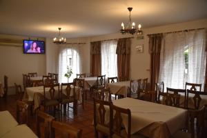 ein Esszimmer mit Tischen und Stühlen und einem Flachbildfernseher in der Unterkunft Los Acebos Cangas in Cangas de Onís