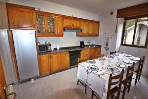 eine Küche mit einem Tisch und einem Kühlschrank in der Unterkunft Casa Razo da Costa in Razo da Costa