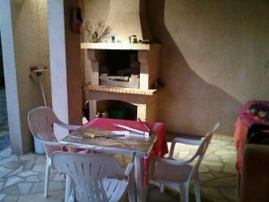 a table and chairs in a room with a fireplace at gîte en sud Ardèche in Ruoms
