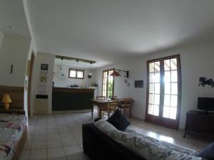 a living room with a couch and a kitchen at gîte en sud Ardèche in Ruoms