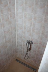 a shower with a hose in a tiled bathroom at Hostel Turist in Zvolen +10 photos