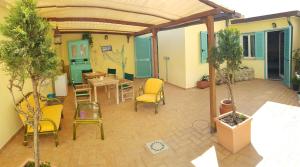 an outdoor patio with chairs and a table and chairs at La Papaya in Marina di Pisa