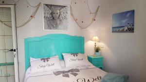 a bedroom with a blue bed with two pillows at La Papaya in Marina di Pisa