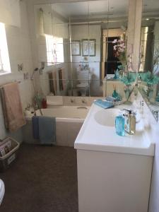 La salle de bains est pourvue d'une baignoire, d'un lavabo et d'une baignoire. dans l'établissement Sunninghill Sojourn, à Kyalami