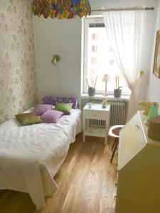 a small bedroom with a bed and a window at Farsta Bed and Breakfast in Stockholm