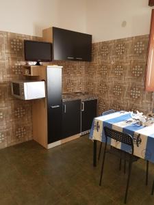 a kitchen with a table and two chairs and a tv at Bilocale Mini Very in San Vito lo Capo