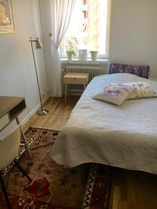 a bedroom with a bed and a desk and a window at Farsta Bed and Breakfast in Stockholm