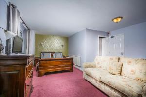 a living room with a couch and a tv at The Chainbridge Hotel in Llangollen
