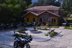 a house with motorcycles parked in front of it at Hotel Pisonay Pueblo in Urubamba