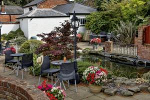 a garden with a table and chairs next to a pond at Best Western Annesley House Hotel in Norwich