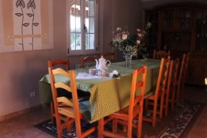 a dining room table with a green table cloth and chairs at Casa rural agro da moa in As Mirans