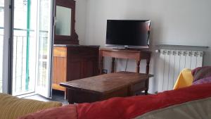 uma sala de estar com televisão e uma mesa com televisão em The Palm House em Santa Margherita Ligure