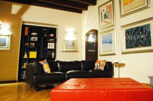 a living room with a black couch and a red ottoman at BeMyGuest Rutigliano in Rutigliano