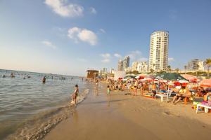 a beach with a bunch of people on the water at Isramax Jerusalem Apartment in Bat-Yam in Bat Yam