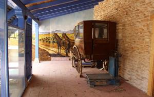 a painting of a horse drawn carriage on a wall at Casa Rural La Tia Lola in Puerto Lápice