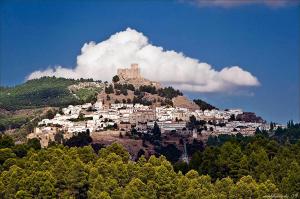 Vivienda Turística Rural Casa Camilo في سيغورا دي لا سييرا: مدينة على قمة تل مع قلعة