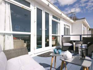 eine Terrasse mit einem Sofa und Stühlen auf dem Balkon in der Unterkunft Sail Away Holiday Villa in Ventnor