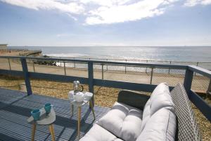 einen Balkon mit einem Sofa und Strandblick in der Unterkunft Sail Away Holiday Villa in Ventnor